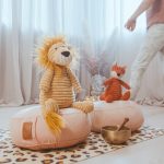 Kuscheltiere mit Kind im Hintergrund bei der Online Kinderyoga Ausbildung